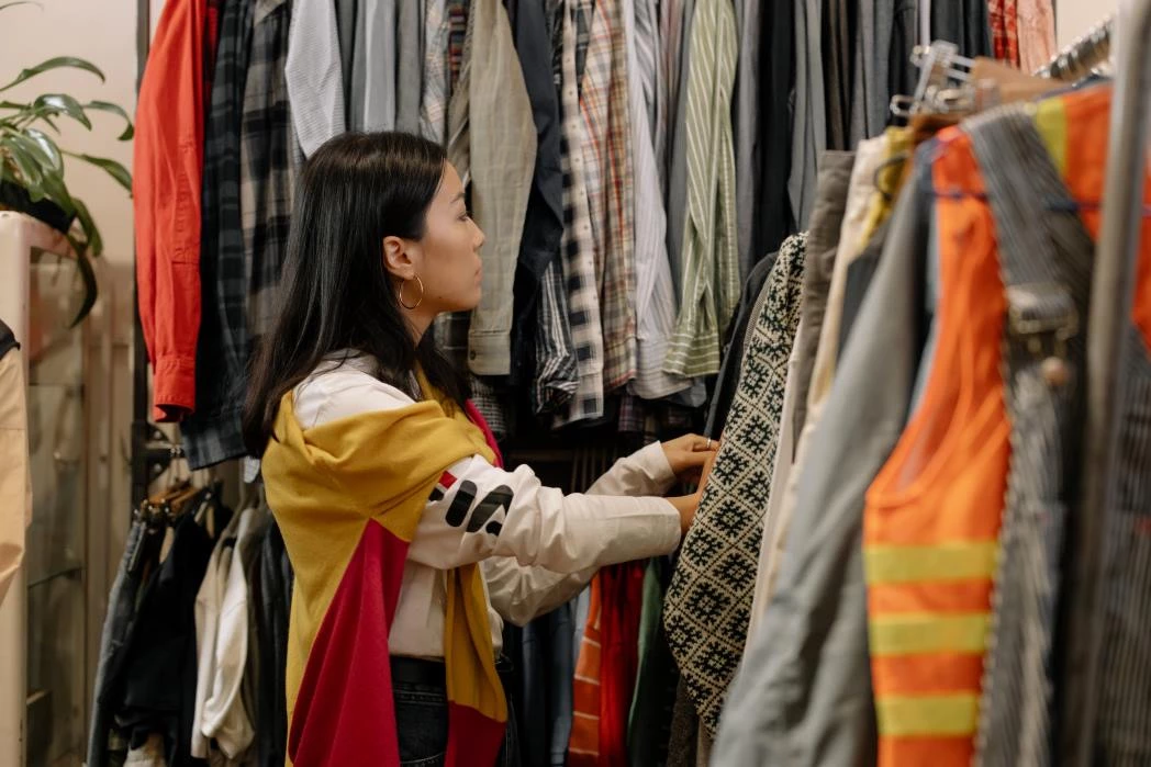 A woman buying second-hand clothes from a farmers market